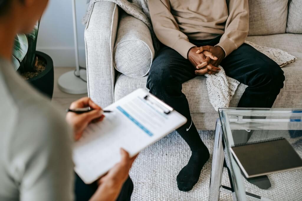 A woman doing consultation on a man for electrolysis hair removal